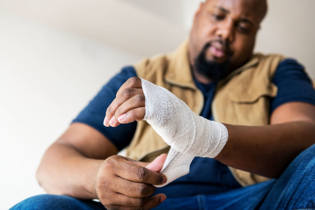 Man wrapping injured hand
